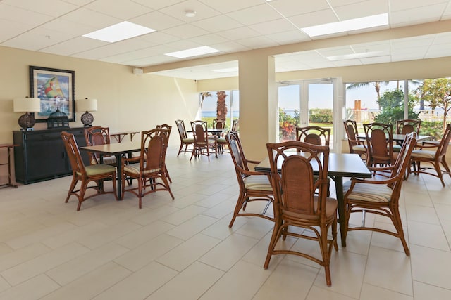 tiled dining space with a paneled ceiling