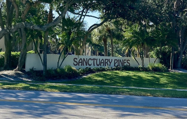 community / neighborhood sign featuring a lawn