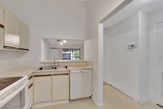 kitchen with sink, white appliances, and cream cabinetry