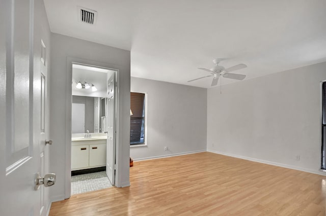 empty room featuring ceiling fan, sink, and light hardwood / wood-style flooring