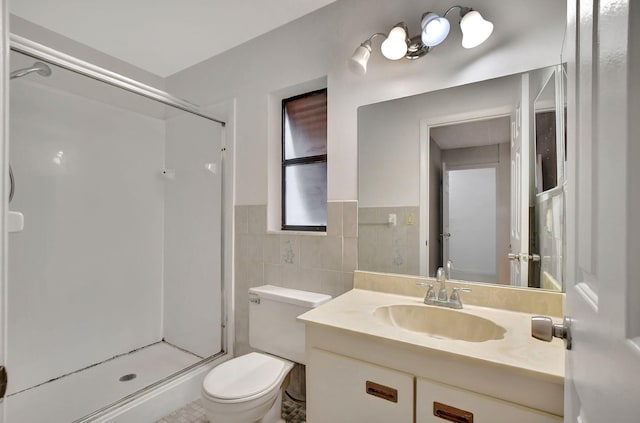 bathroom with a shower with door, toilet, vanity, and tile walls