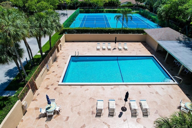 view of swimming pool with tennis court