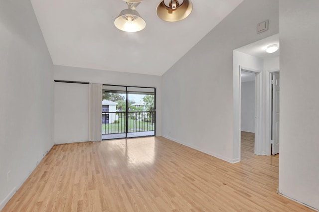 spare room with light hardwood / wood-style flooring and vaulted ceiling