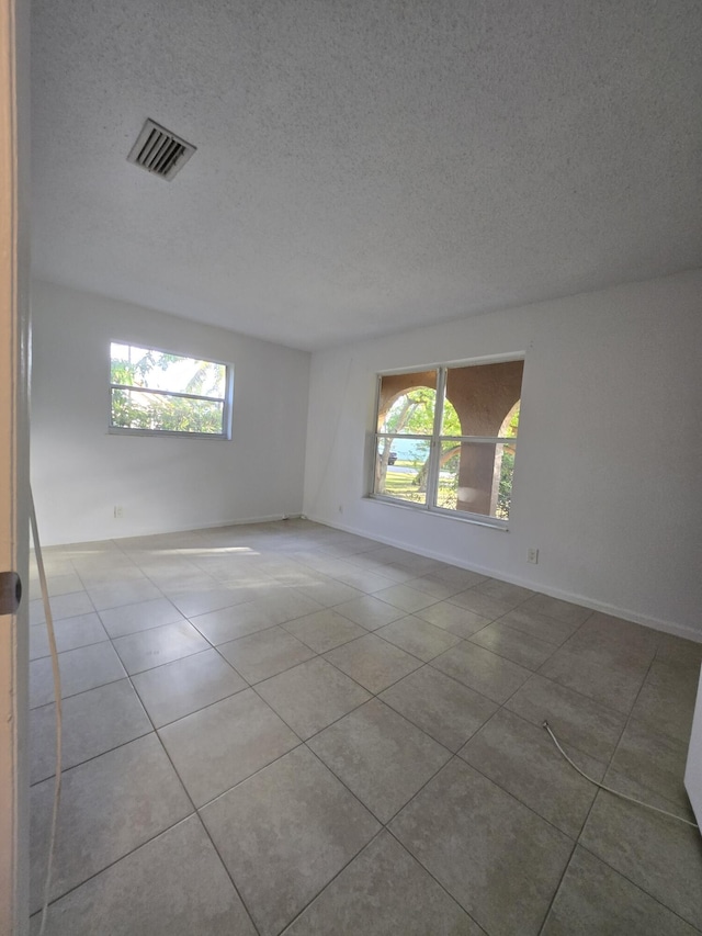 unfurnished room featuring tile patterned floors and a textured ceiling