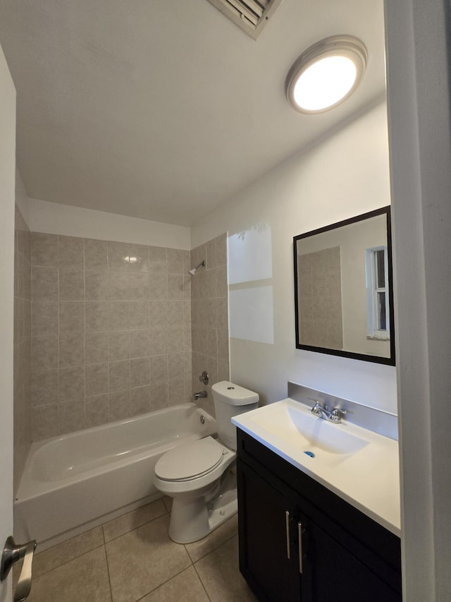 full bathroom with tile patterned flooring, vanity, tiled shower / bath combo, and toilet