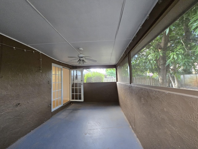 unfurnished sunroom with ceiling fan