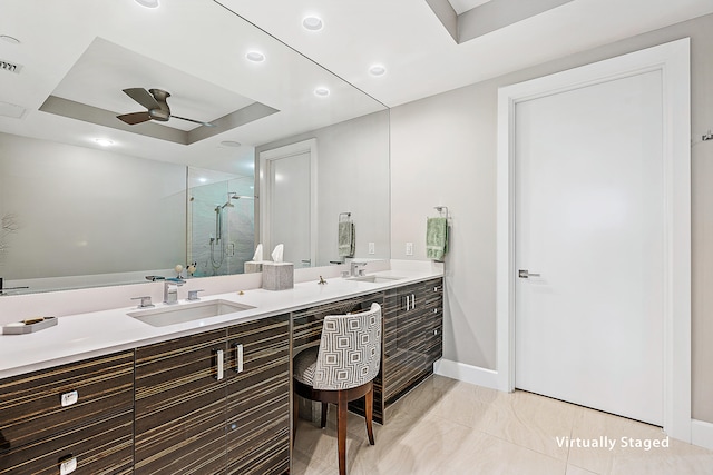 bathroom with vanity, a tray ceiling, ceiling fan, and a shower with shower door