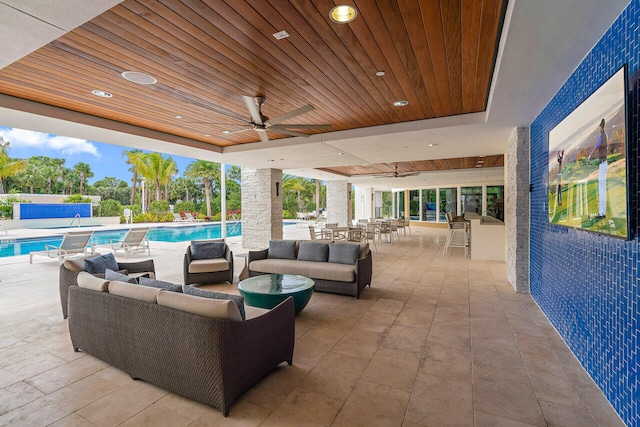 view of patio / terrace featuring exterior bar, an outdoor living space, and ceiling fan