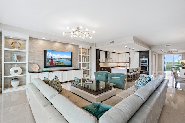 living room with built in features, sink, and an inviting chandelier