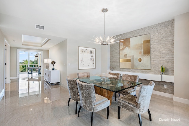 dining room featuring a notable chandelier and a raised ceiling