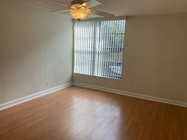 empty room with ceiling fan, a textured ceiling, and light hardwood / wood-style flooring