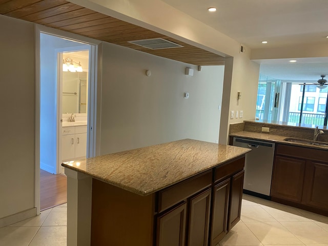 kitchen featuring stainless steel dishwasher, dark brown cabinets, a kitchen island, and sink