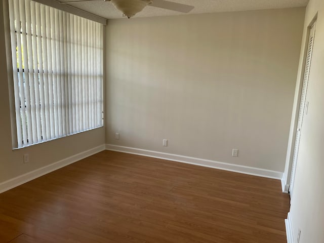 spare room featuring a textured ceiling, ceiling fan, and dark hardwood / wood-style floors