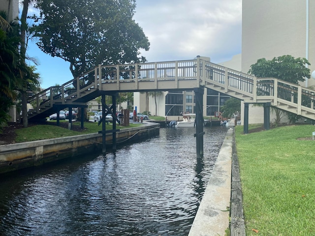 dock area with a lawn and a deck with water view