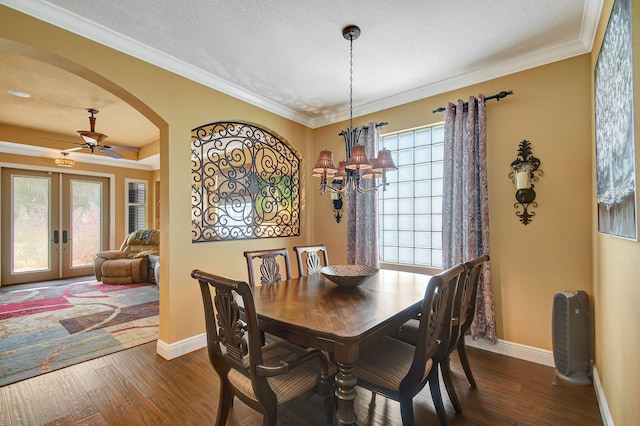 dining room featuring ceiling fan with notable chandelier, crown molding, dark wood-type flooring, and french doors