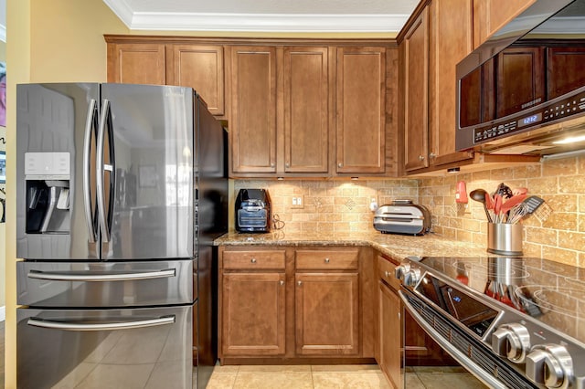 kitchen featuring light stone countertops, stainless steel appliances, backsplash, light tile patterned floors, and ornamental molding