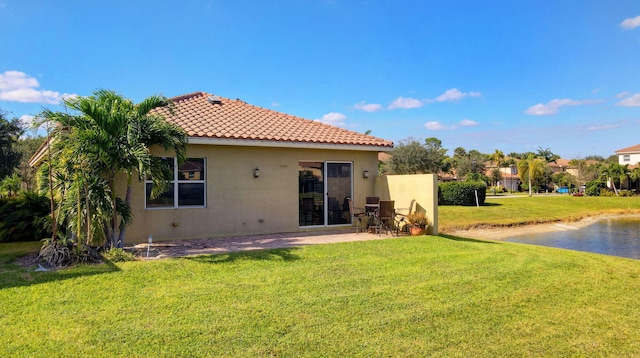 rear view of property with a lawn and a patio