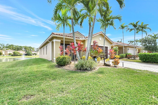 view of front of house featuring decorative driveway, stucco siding, an attached garage, a tiled roof, and a front lawn