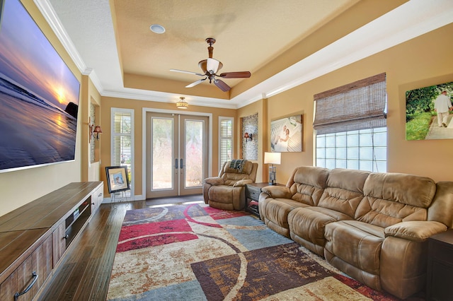 living room with french doors, a raised ceiling, crown molding, ceiling fan, and dark hardwood / wood-style flooring