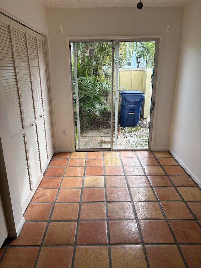 doorway to outside featuring a textured ceiling