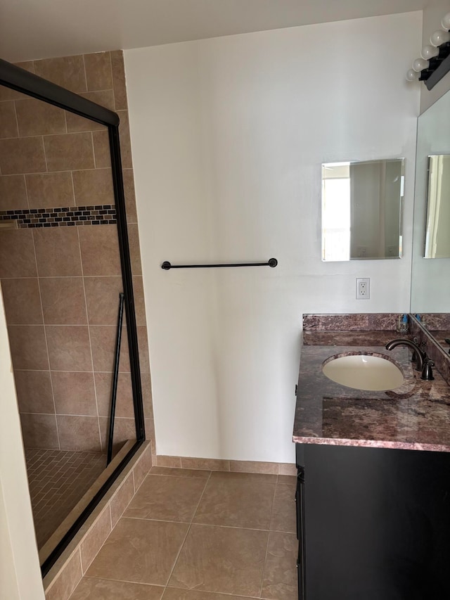 bathroom with vanity, tile patterned floors, and a shower with door