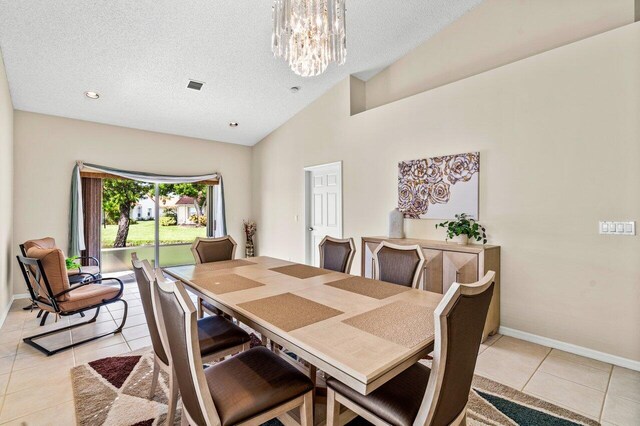 15321 Lake Wildflower Rd, Delray Beach, FL 33484 - dining room with light tile patterned floors, a chandelier, baseboards, a textured ceiling, and high vaulted ceiling