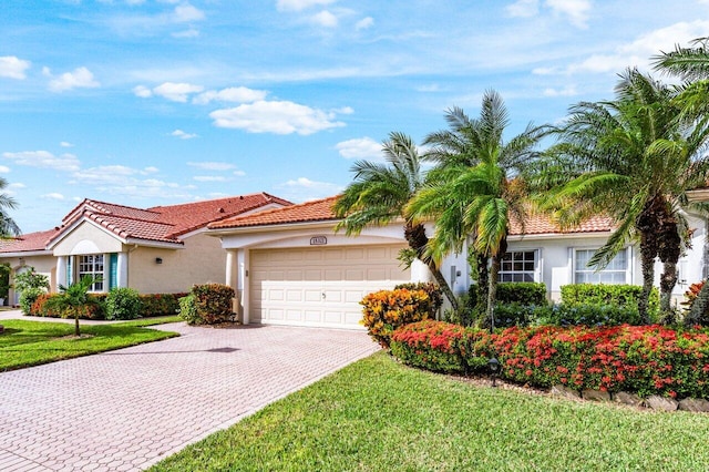 mediterranean / spanish-style home featuring a garage and a front lawn