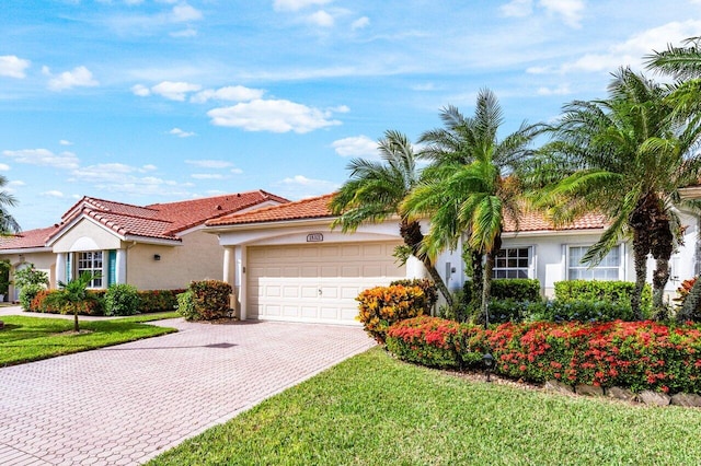 15321 Lake Wildflower Rd, Delray Beach, FL 33484 - mediterranean / spanish home featuring decorative driveway, stucco siding, a garage, a front lawn, and a tiled roof