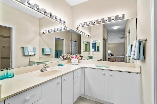 bathroom with tile patterned flooring, vanity, and a textured ceiling