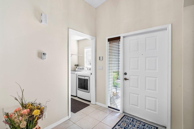 foyer entrance featuring light tile patterned floors and washing machine and clothes dryer