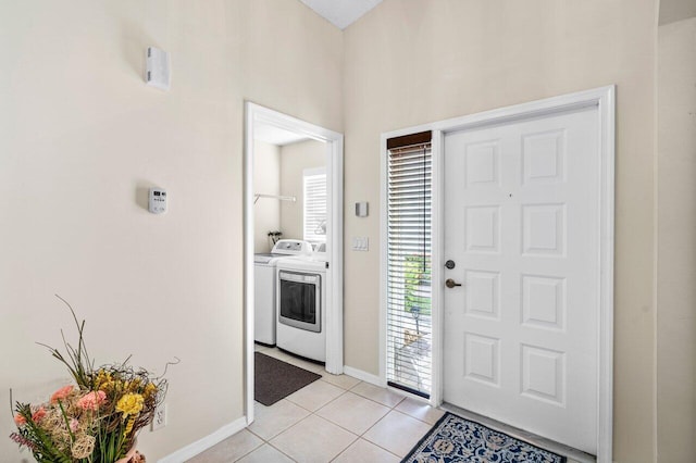 15321 Lake Wildflower Rd, Delray Beach, FL 33484 - foyer entrance with washer and dryer, light tile patterned floors, and baseboards