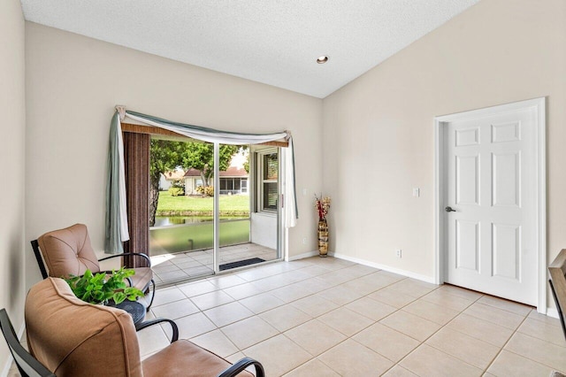 interior space with light tile patterned flooring, lofted ceiling, and a textured ceiling