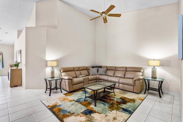 living room featuring ceiling fan, light tile patterned floors, a textured ceiling, and high vaulted ceiling