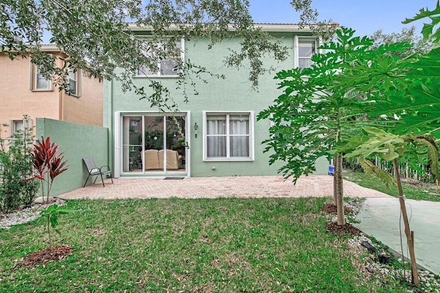 rear view of property featuring a yard and a patio