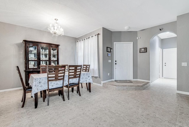 dining room featuring a textured ceiling and a notable chandelier