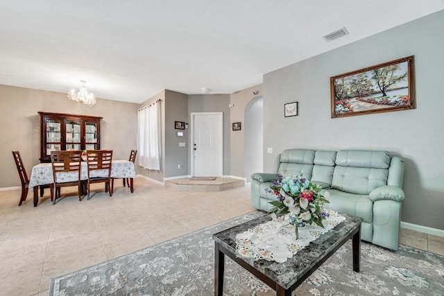 tiled living room with a notable chandelier