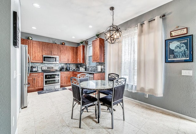 kitchen featuring a chandelier, decorative light fixtures, stainless steel appliances, and tasteful backsplash