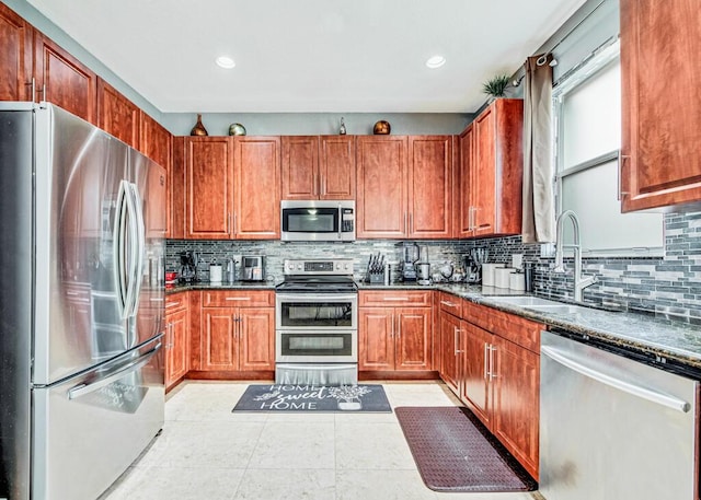 kitchen featuring decorative backsplash, sink, light tile patterned floors, and stainless steel appliances