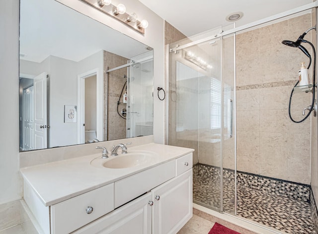 bathroom with tile patterned floors, vanity, toilet, and an enclosed shower