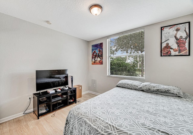 bedroom featuring hardwood / wood-style floors and a textured ceiling