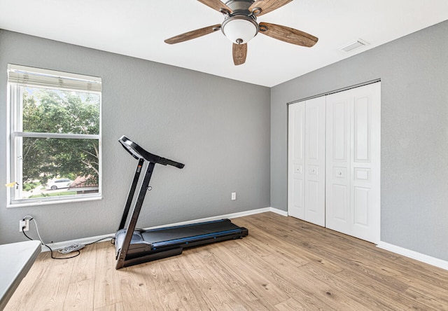 exercise area with light wood-type flooring and ceiling fan