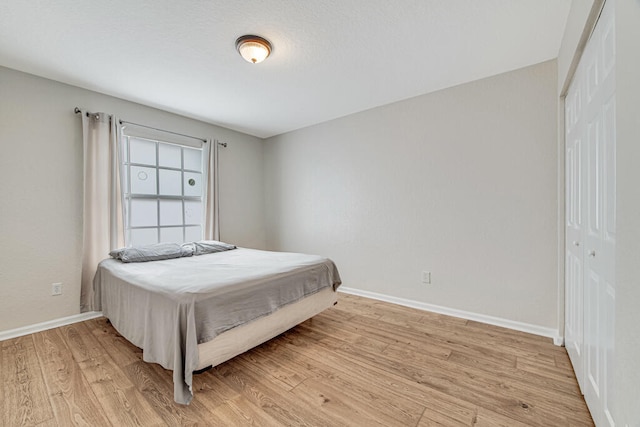 bedroom with a closet and light hardwood / wood-style flooring