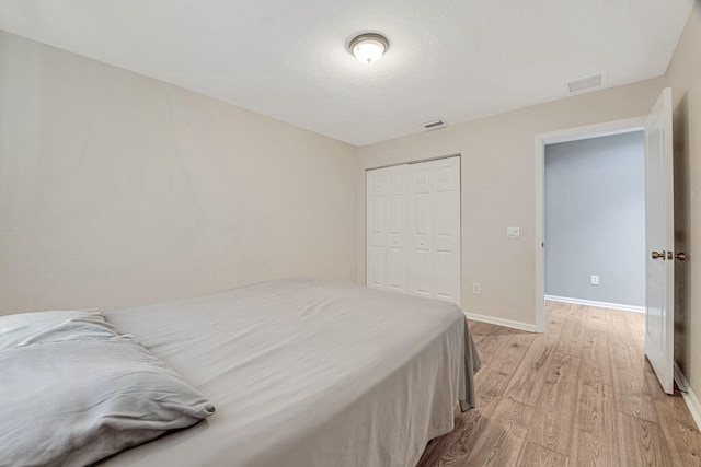 bedroom with light wood-type flooring and a closet