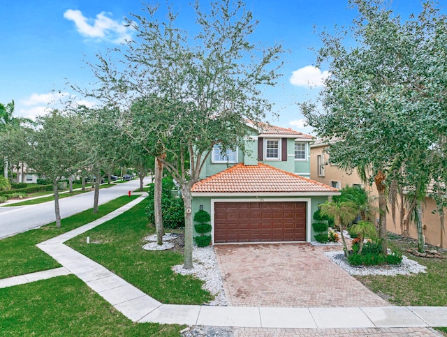 mediterranean / spanish-style home featuring a garage and a front lawn