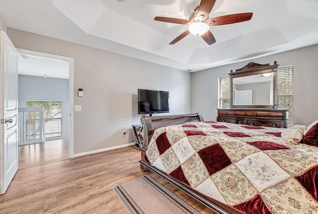 bedroom with a tray ceiling, multiple windows, and ceiling fan