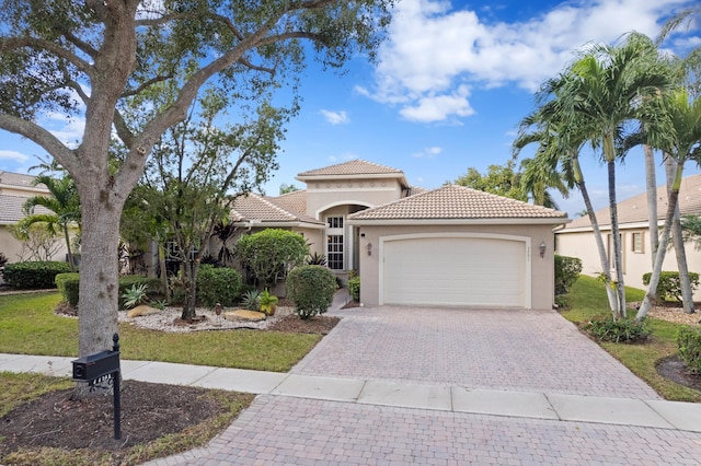 mediterranean / spanish home with a garage and a front yard