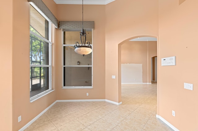 unfurnished dining area featuring crown molding, light tile patterned floors, and a notable chandelier