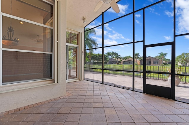 unfurnished sunroom featuring ceiling fan