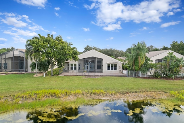 back of property with a yard and a water view