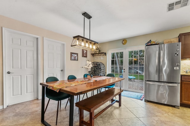 tiled dining room featuring french doors